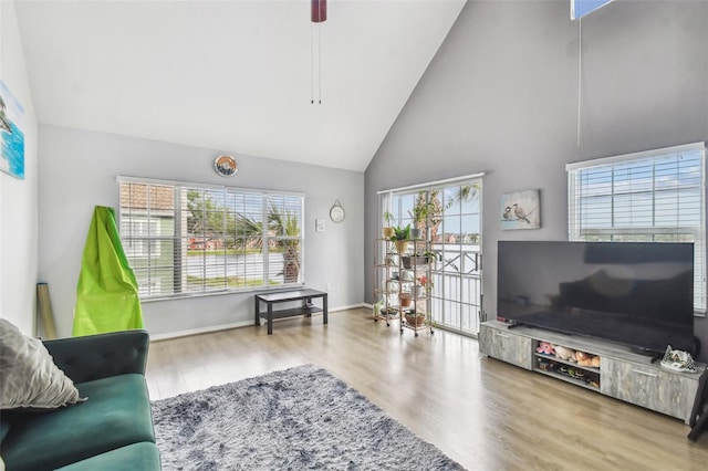 living room featuring ceiling fan, high vaulted ceiling, a healthy amount of sunlight, and hardwood / wood-style flooring