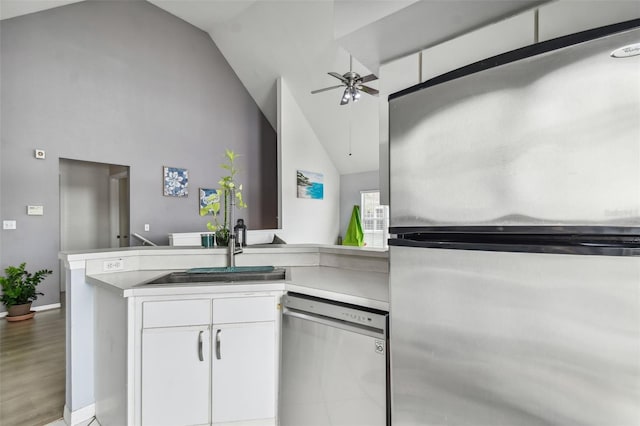 kitchen with hardwood / wood-style floors, white cabinetry, ceiling fan, kitchen peninsula, and stainless steel appliances