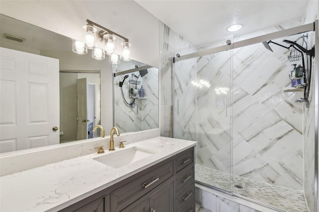 bathroom with vanity and a shower with door