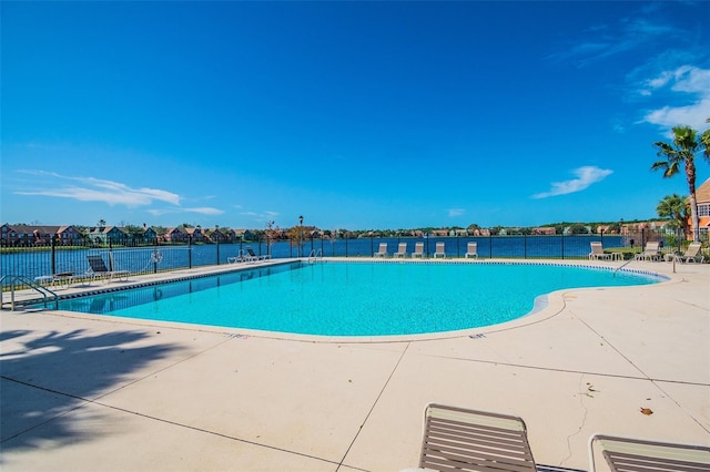 view of swimming pool with a patio area and a water view