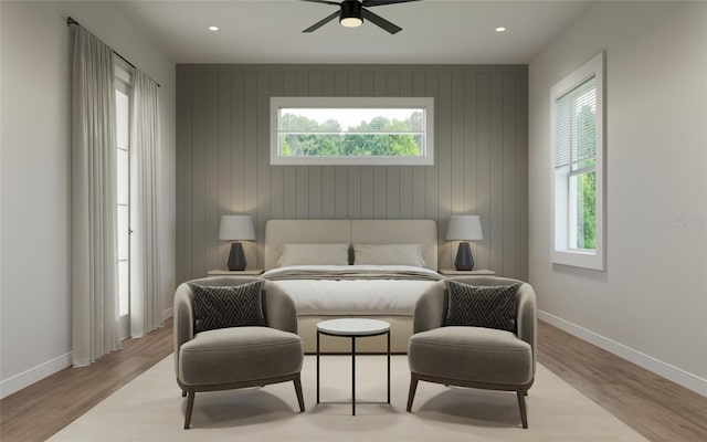 bedroom with ceiling fan, light wood-type flooring, and multiple windows