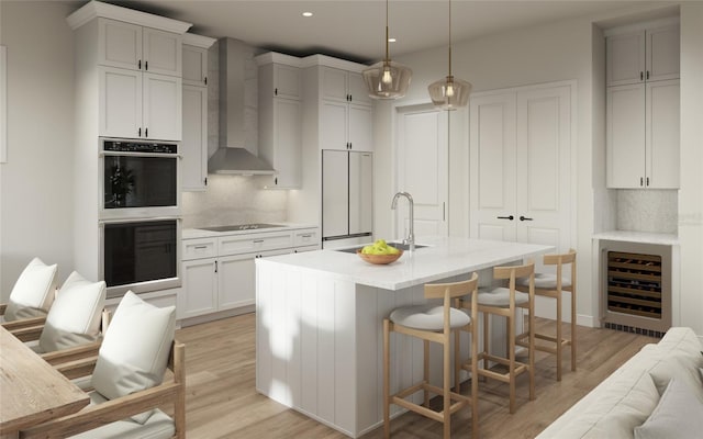 kitchen featuring stainless steel double oven, beverage cooler, wall chimney exhaust hood, decorative light fixtures, and tasteful backsplash