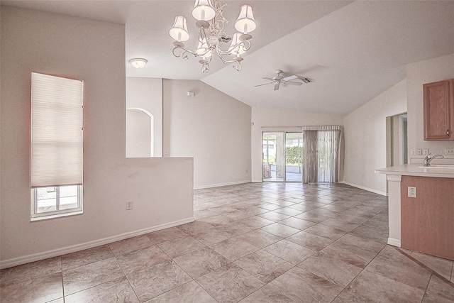 unfurnished dining area featuring a textured ceiling, ceiling fan with notable chandelier, lofted ceiling, and sink