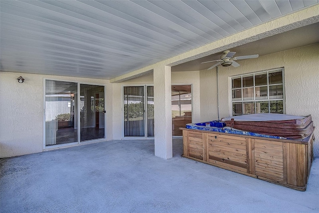 view of patio with ceiling fan and a hot tub