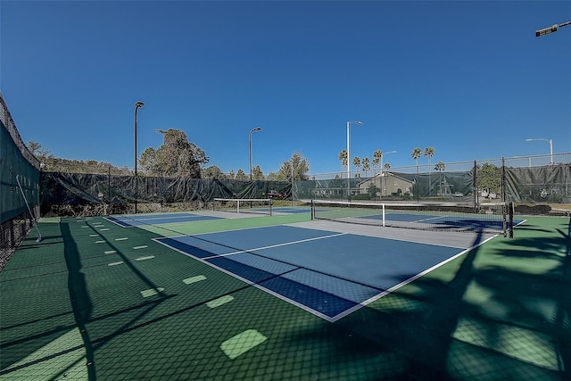 view of tennis court with basketball hoop