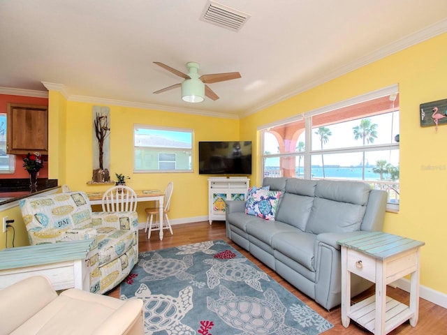 living room with hardwood / wood-style floors, ornamental molding, and ceiling fan