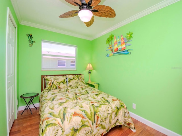 bedroom featuring ornamental molding, wood-type flooring, and ceiling fan