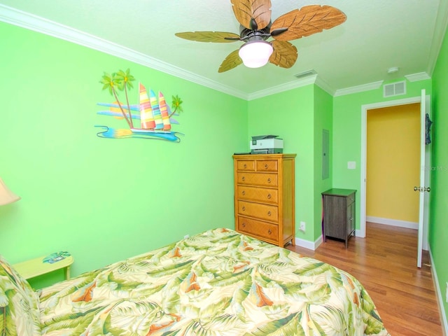 bedroom with ornamental molding, electric panel, ceiling fan, and light hardwood / wood-style flooring