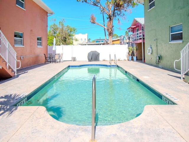 view of swimming pool with a grill and a patio