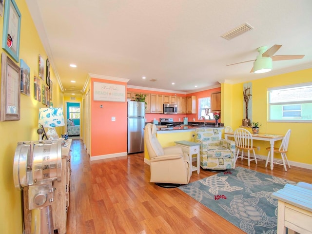 living room with sink, crown molding, ceiling fan, and light wood-type flooring