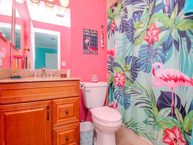 bathroom with ornamental molding, vanity, and toilet