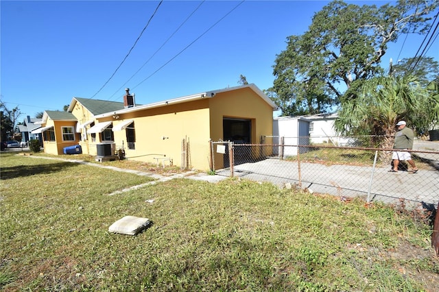 view of side of property with cooling unit and a yard