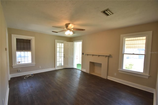 unfurnished living room featuring ceiling fan and dark wood-type flooring