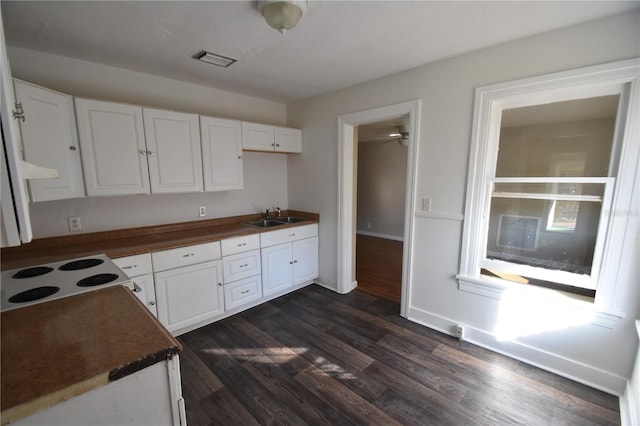 kitchen featuring white cabinets, white cooktop, dark hardwood / wood-style flooring, and sink