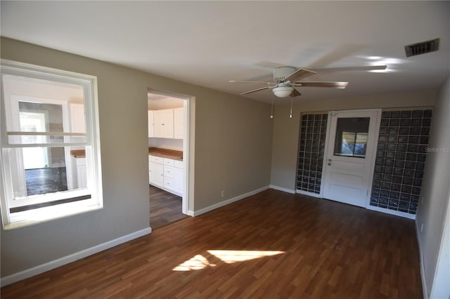 empty room with ceiling fan and dark hardwood / wood-style flooring