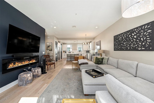 living room featuring light hardwood / wood-style flooring and an inviting chandelier