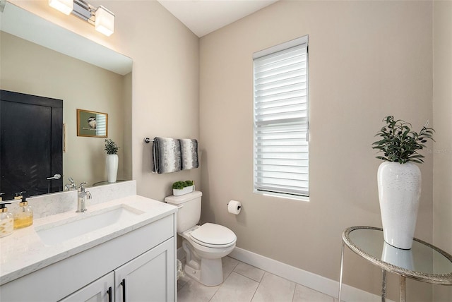 bathroom featuring tile patterned flooring, vanity, a healthy amount of sunlight, and toilet