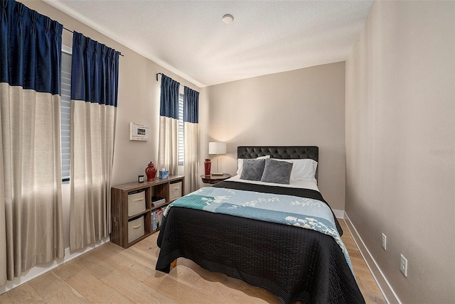 bedroom featuring light hardwood / wood-style floors and a textured ceiling