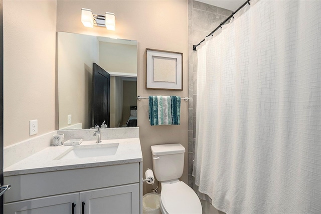 bathroom featuring vanity, toilet, and walk in shower