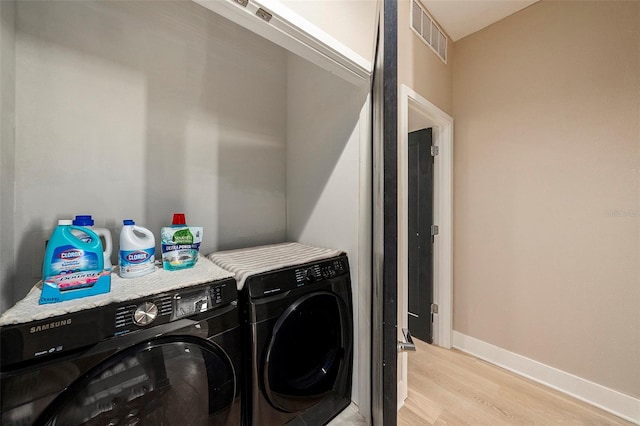 washroom featuring light hardwood / wood-style floors and washing machine and clothes dryer