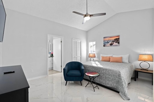 bedroom featuring a closet, ensuite bath, ceiling fan, and lofted ceiling