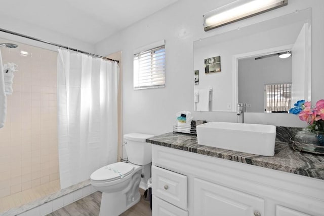 bathroom featuring hardwood / wood-style floors, vanity, toilet, and walk in shower