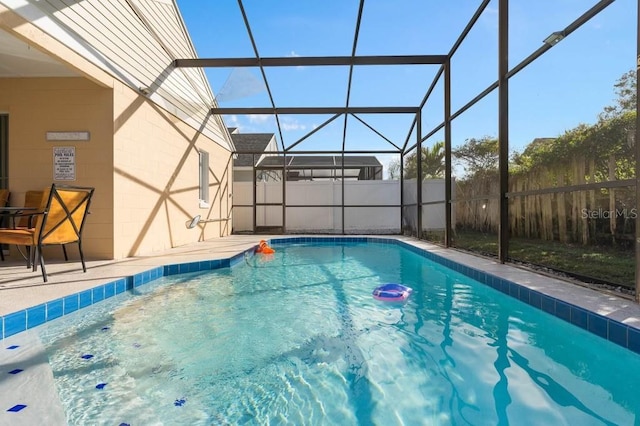 view of pool featuring glass enclosure and a patio area