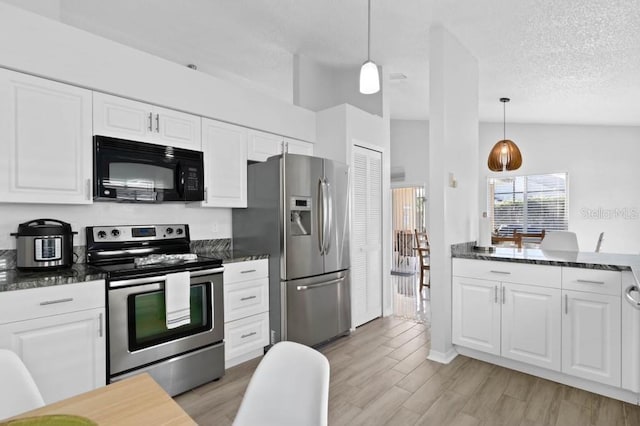 kitchen featuring stainless steel appliances, light hardwood / wood-style flooring, a textured ceiling, lofted ceiling, and white cabinets