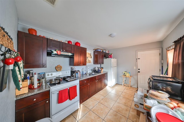 kitchen featuring sink, light tile patterned floors, and white appliances