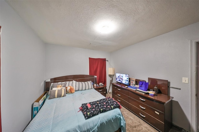 bedroom featuring carpet flooring and a textured ceiling