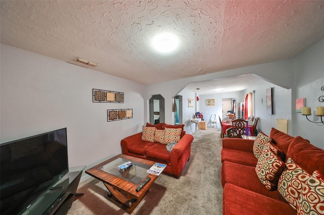 living room with a textured ceiling and carpet floors