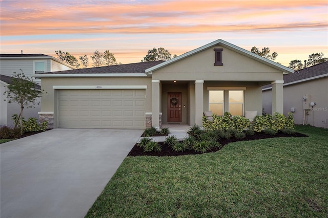 view of front of house featuring a lawn, a garage, and covered porch