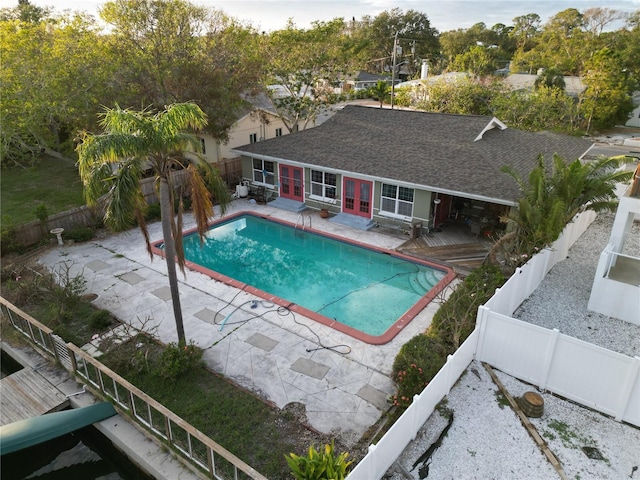 view of swimming pool featuring french doors, a fenced backyard, and a fenced in pool