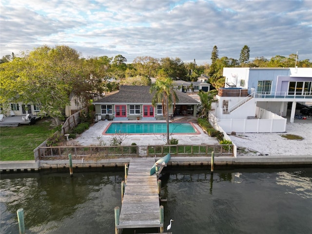 rear view of house with a patio area, a water view, and a fenced backyard