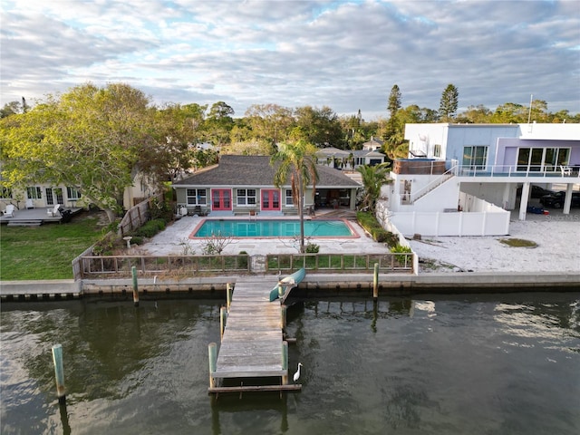 back of house with a patio, a water view, a fenced backyard, and an outdoor pool