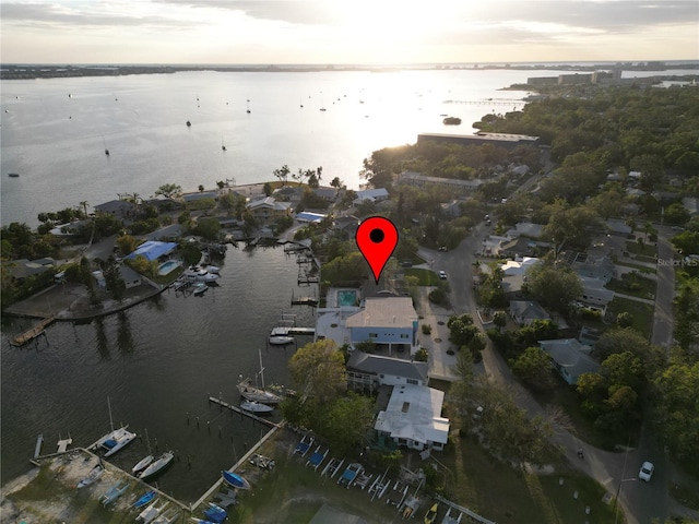 aerial view at dusk featuring a water view