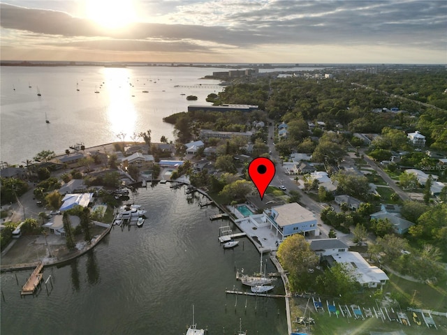 aerial view at dusk featuring a water view