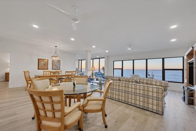 dining space featuring ceiling fan, a water view, and light hardwood / wood-style floors