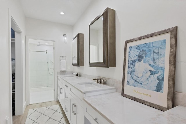 bathroom featuring a tile shower, vanity, and hardwood / wood-style flooring