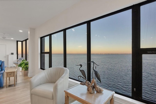 living room with a water view and light hardwood / wood-style floors