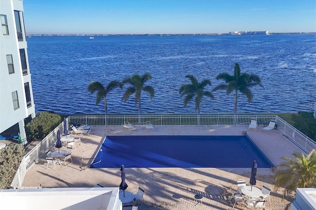 view of swimming pool featuring a patio area and a water view