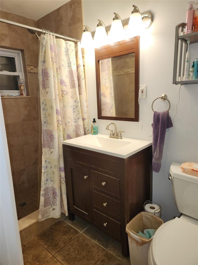 bathroom featuring tile patterned floors, vanity, toilet, and walk in shower