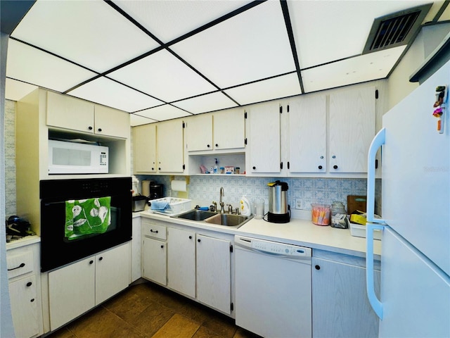 kitchen featuring white appliances, tasteful backsplash, a paneled ceiling, and sink