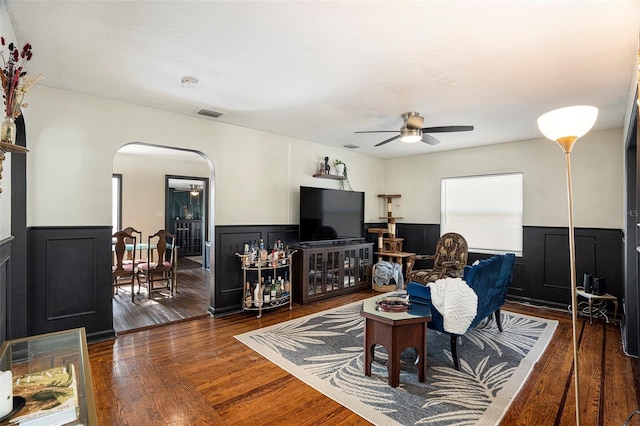 living room featuring ceiling fan and dark hardwood / wood-style floors