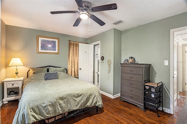 bedroom with a textured ceiling, dark hardwood / wood-style flooring, and ceiling fan