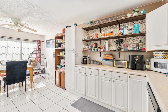 kitchen featuring white cabinets, a textured ceiling, tasteful backsplash, and ceiling fan