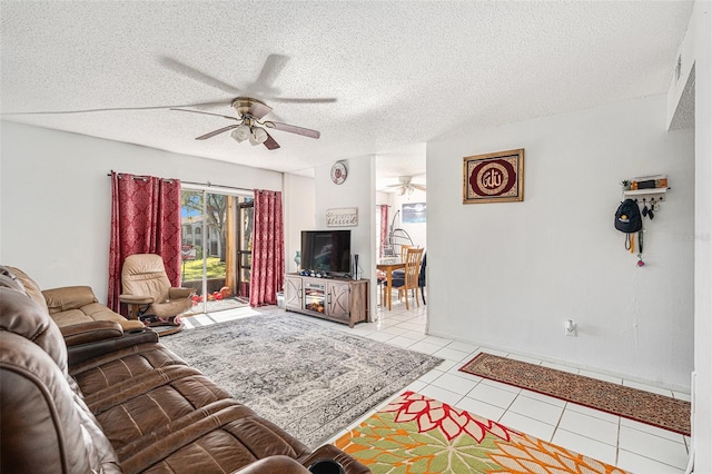 living room with a textured ceiling, ceiling fan, and light tile patterned flooring