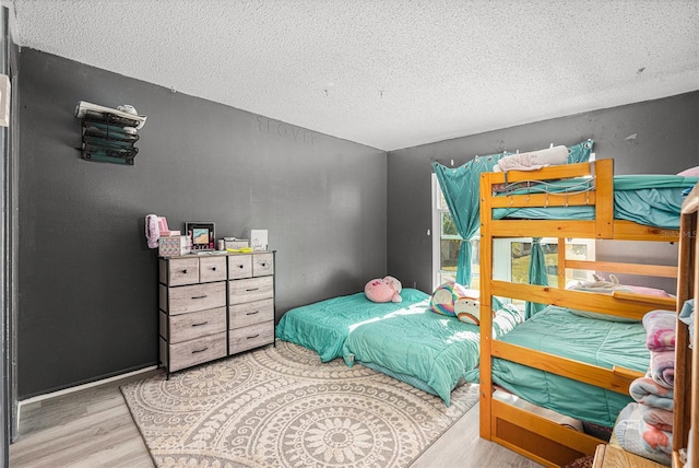 bedroom featuring a textured ceiling and light hardwood / wood-style flooring