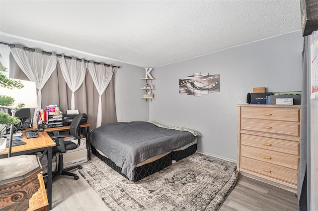 bedroom featuring wood-type flooring and a textured ceiling