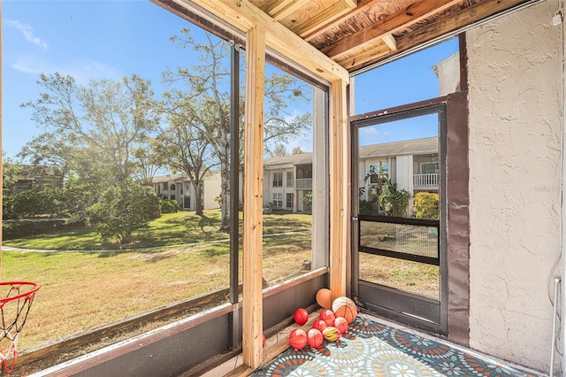 unfurnished sunroom featuring beamed ceiling and wood ceiling